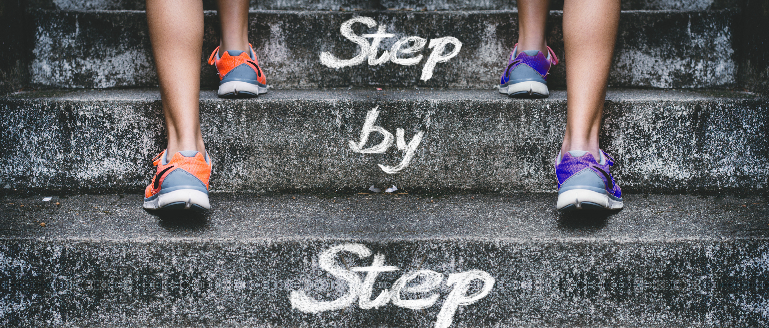 Bild einer Treppe mit der Aufschrift Step by Step
