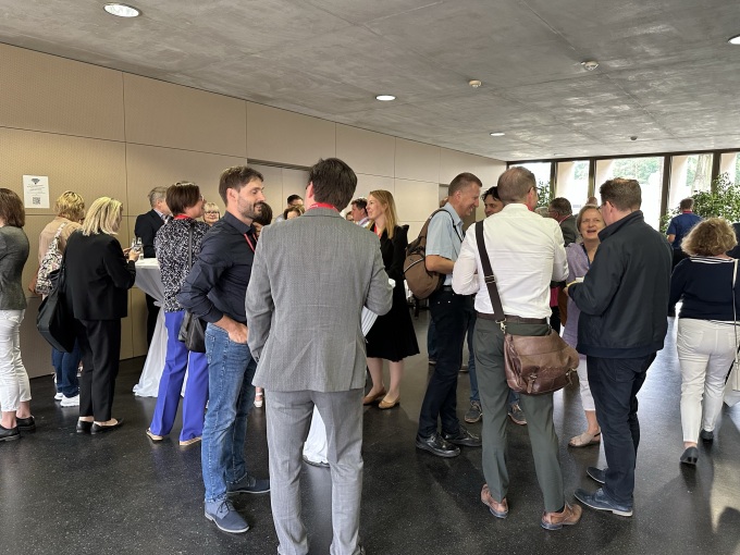 Teilnehmende des Symposiums reden an Stehtischen miteinander